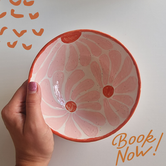 Bunte Müslischale mit rot-rosa aufgemalter Blume und einem Icon "Book now"